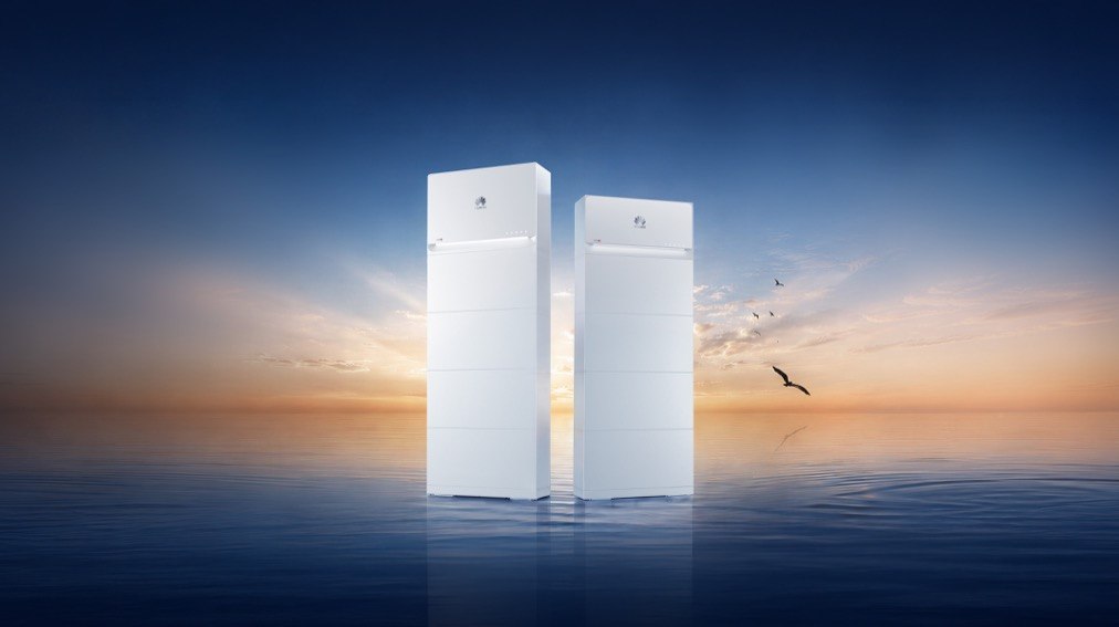 Due sistemi di accumulo Huawei LUTERRA S2 con torri di altezza diversa su uno sfondo marino al tramonto.